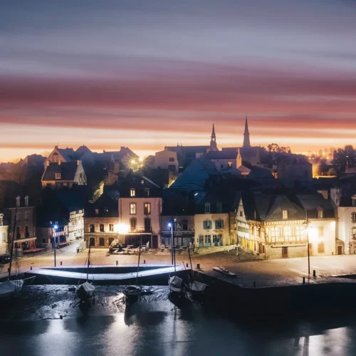 Photographie du port de Saint-Goustan à l'aube avec des lumières allumées et un ciel coloré