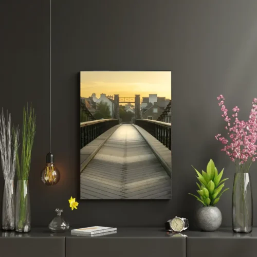 Fotografía enmarcada del amanecer sobre el puente colgante de Le Bono, expuesta en un elegante interior