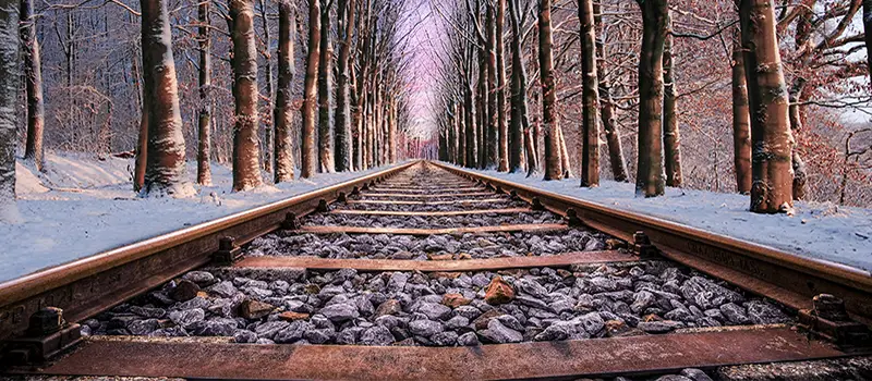 Rails traversant une forêt enneigée, effet de lignes directrices en composition