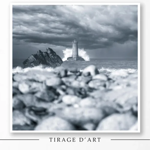Lighthouse of the Four under the storm in black and white with waves and rocks in Brittany