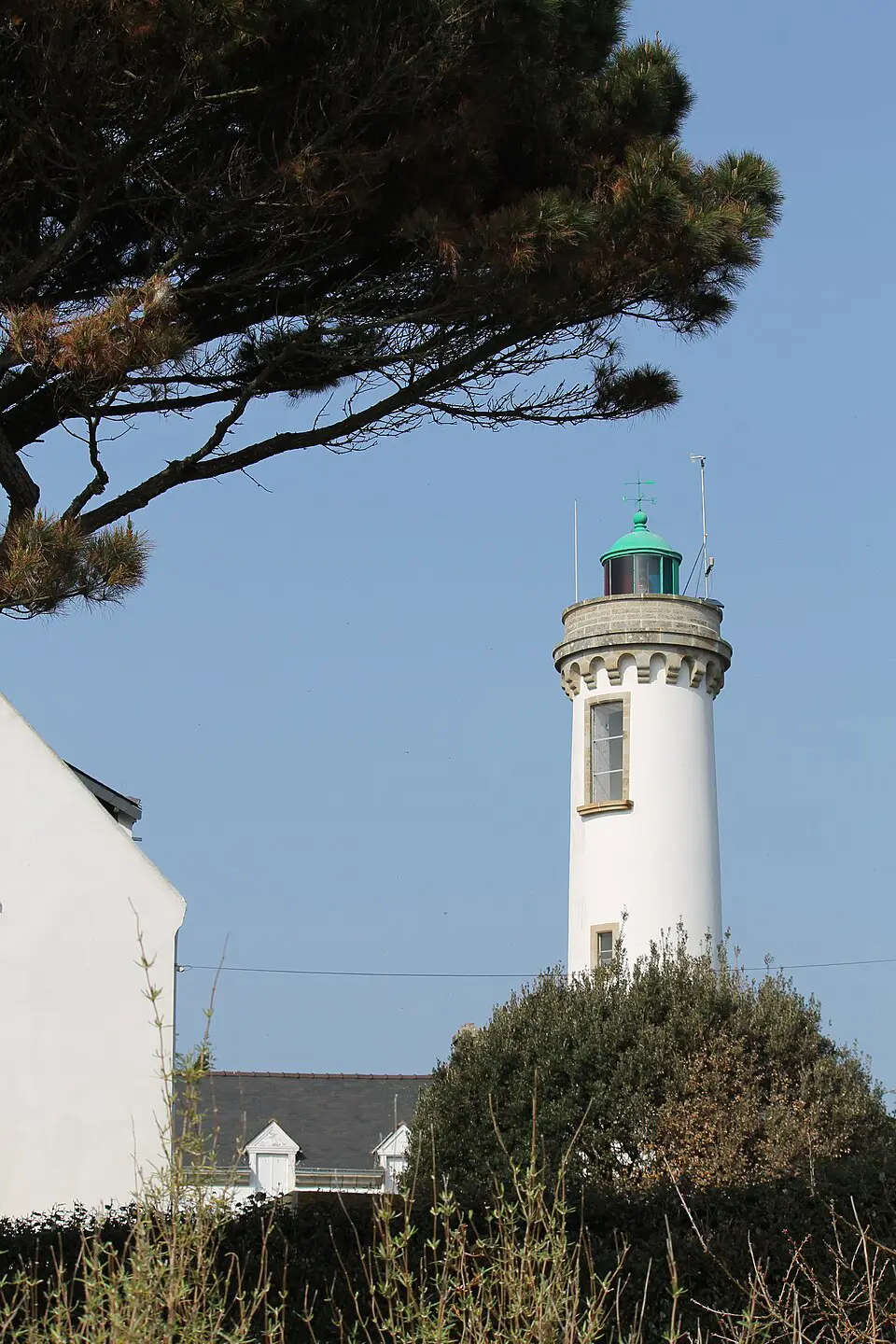 Von Pinien umgebener Leuchtturm von Port-Navalo am Eingang zum Golf von Morbihan
